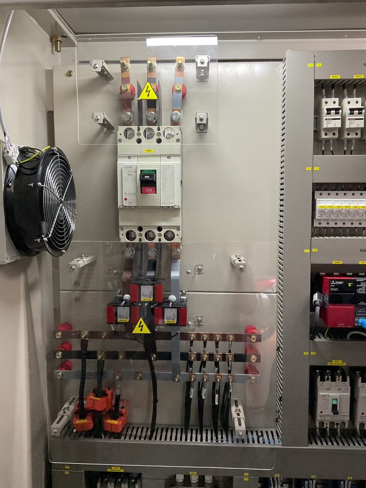 Main breaker, current transformers and copper busbar behind a clear protective cover